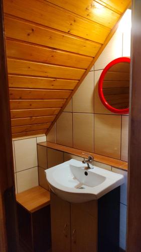 a bathroom with a sink and a red mirror at Domki Żaklin in Berezka
