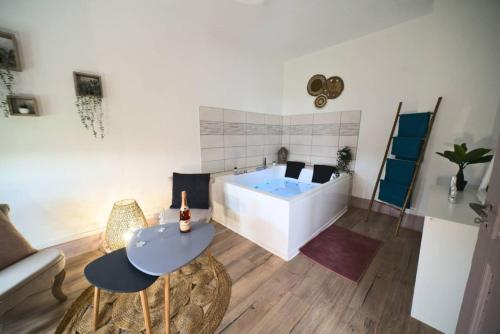 sala de estar con bañera, mesa y sillas en PURE#SPA#JACUZZI#Mulhouse, en Mulhouse