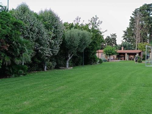 a large grass field with a house in the background at Σύγχρονη αγροικία in Nafpaktos