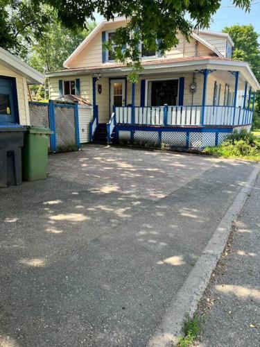 a house with a blue fence in front of it at Petite maison 2 bedrooms in Lévis