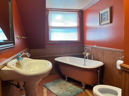 a bathroom with a tub and a sink and a toilet at Petite maison 2 bedrooms in Lévis