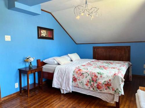 a bedroom with a bed and a blue wall at Petite maison 2 bedrooms in Lévis