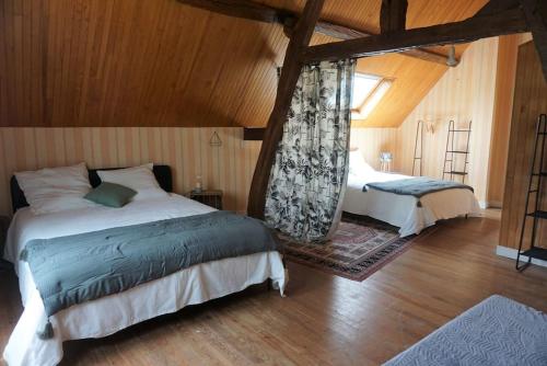 une chambre avec deux lits et une grande fenêtre dans l'établissement L'Escapade du Vexin normand - Spa, à Longchamps