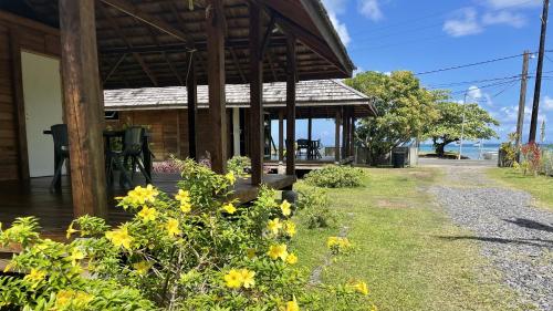 a house with yellow flowers in front of it at RAIATEA - Orion Hoe Bungalow in Uturoa