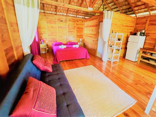 a living room with a couch and a table at RAIATEA - Orion Pool Bungalow in Uturoa