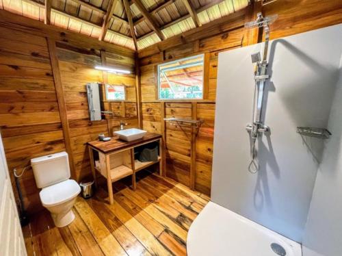 a bathroom with a toilet and a sink at RAIATEA - Orion Pool Bungalow in Uturoa
