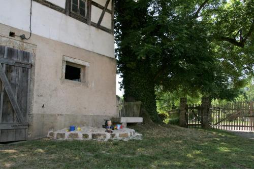 a building with a bench and a tree and a fence at Schlossmühle Schieritz in der Nähe von Meißen in Schieritz