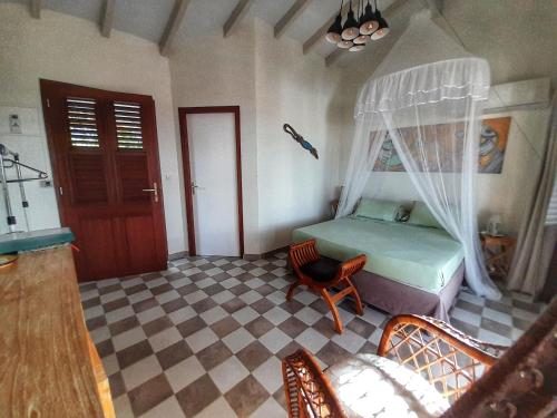 1 dormitorio con 1 cama, 1 sofá y 1 silla en Studio Frangipani dans Villa Fleurs des Iles, en Le Vauclin