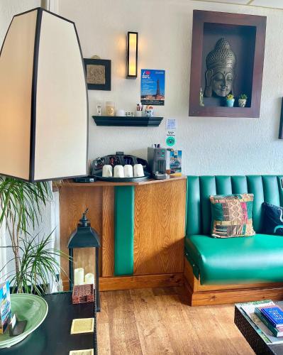 a living room with a green couch and a table at Clifton Court Hotel in Blackpool