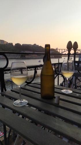 a bottle of wine and two glasses on a bench at Studio Douro River Views in Porto