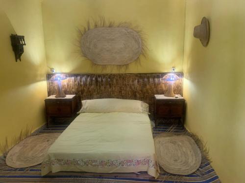 - un lit dans un dortoir avec deux lampes latérales dans l'établissement Dar Garindi, à Assilah