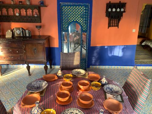 una mesa con tazones y platos en una habitación en Dar Garindi, en Asilah