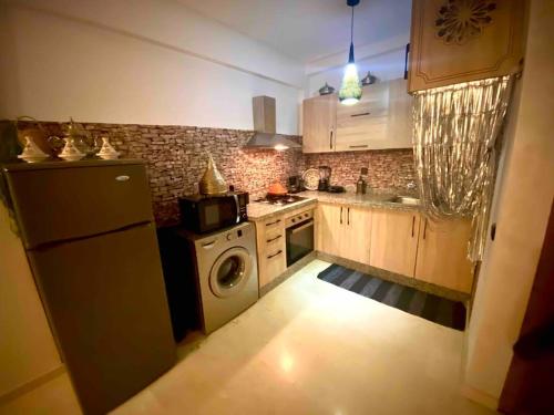 Splendido appartamento a Gueliz في مراكش: مطبخ مع ثلاجة وغسالة ملابس