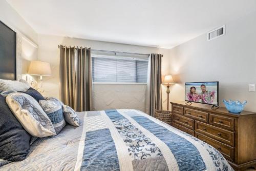 1 dormitorio con cama y vestidor con TV en Casa de Emdeko 221, en Kailua-Kona