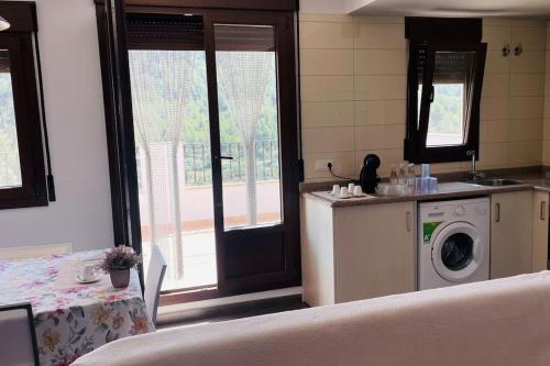 a kitchen with a washing machine next to a window at El Retiro de Casa Nieves in Villahermosa del Río