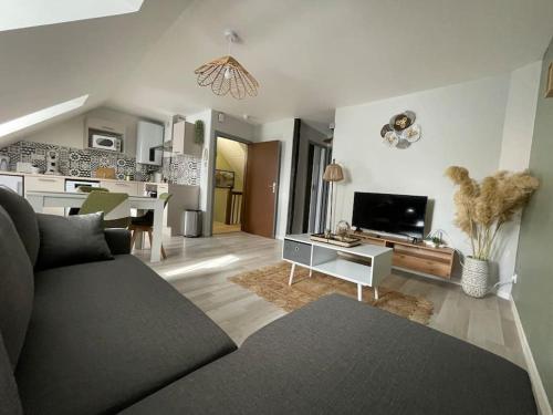 a living room with a couch and a dining room at T2 cœur de ville thème bohème in Rodez