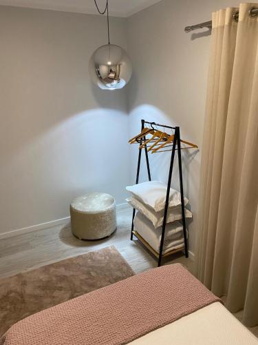 a room with a bed and a stool and a lamp at Pombal Suite in Pombal