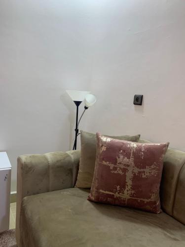 a couch with a pillow on it in a living room at Hotel la Perle d'Arfoud in Erfoud