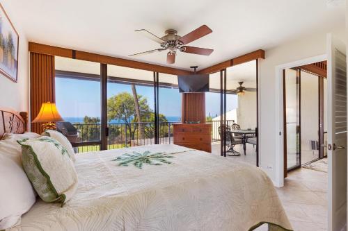 um quarto com uma cama e uma varanda em Country Club Villas 302 em Kailua-Kona