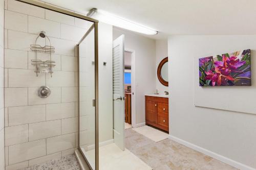 W łazience znajduje się prysznic ze szklanymi drzwiami. w obiekcie Country Club Villas 302 w mieście Kailua-Kona