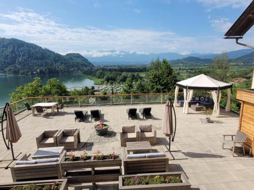a patio with chairs and tables and a view of a lake at Jägerhotel in Annenheim