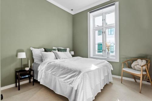 1 dormitorio con cama blanca y ventana en Beautiful apartment in the heart of Oslo!, en Oslo