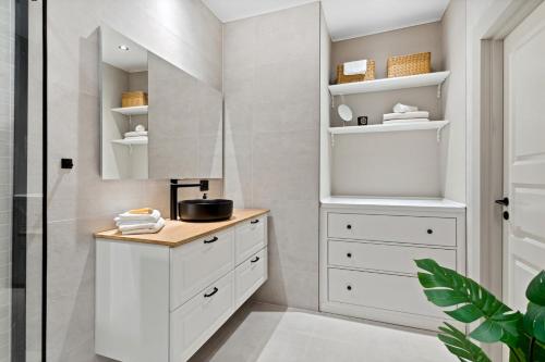 baño con armarios blancos y espejo en Beautiful apartment in the heart of Oslo!, en Oslo