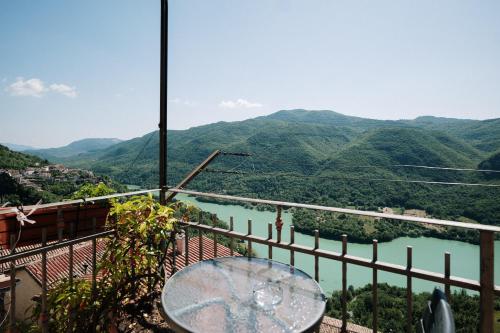 a table on a balcony with a view of a river at Lago del Turano - Guest House il Nido dell'Aquila in Ascrea