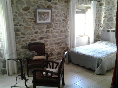 een slaapkamer met een bed en een tafel en stoelen bij Le Mas de la Musardiere chambres d hotes in Les Assions