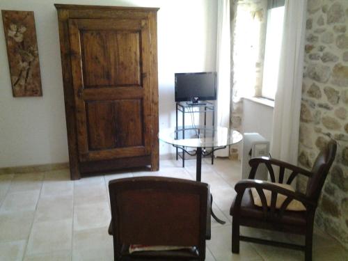 a living room with a table and chairs and a door at Le Mas de la Musardiere chambres d hotes in Les Assions