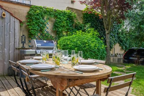 uma mesa de madeira com pratos e copos em Stunning family home in Versailles - Welkeys em Versailles