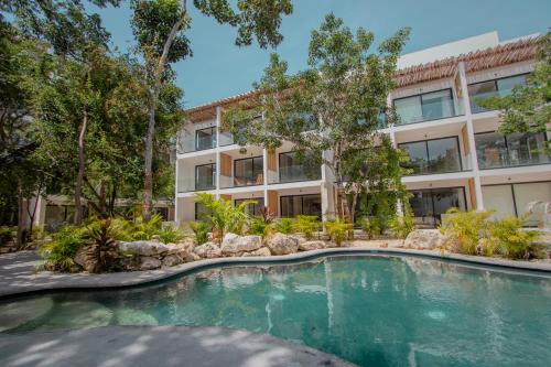 a swimming pool in front of a building at Erena Tulum in Tulum