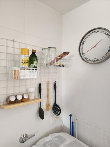 a kitchen with a clock and utensils on the wall at Departamento XIBI in San Salvador de Jujuy