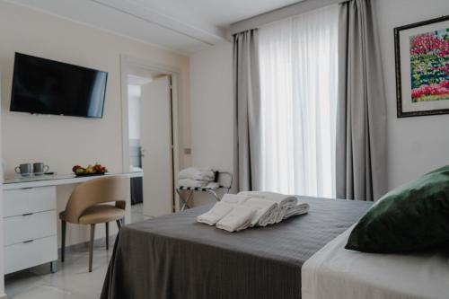 a white bedroom with a bed and a desk at RIMIR Hotel & Centro Benessere in Montecilfone