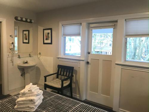 a bathroom with a bed and a sink and a chair at Cambie Lodge in Vancouver