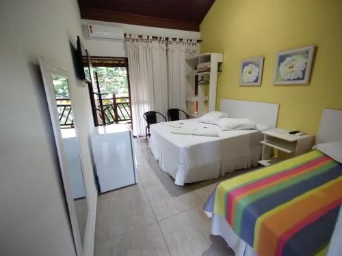 a bedroom with two beds and a balcony at Pousada Água Marinha in Caraguatatuba