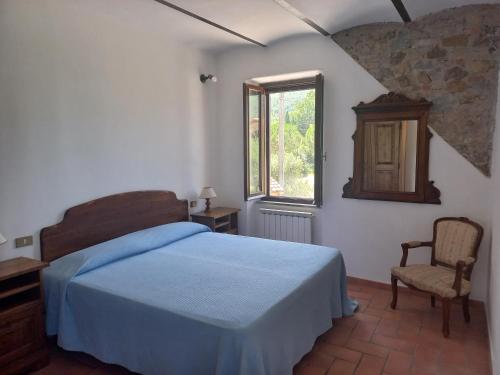 een slaapkamer met een bed, een stoel en een raam bij Agriturismo La Bulletta in Perugia