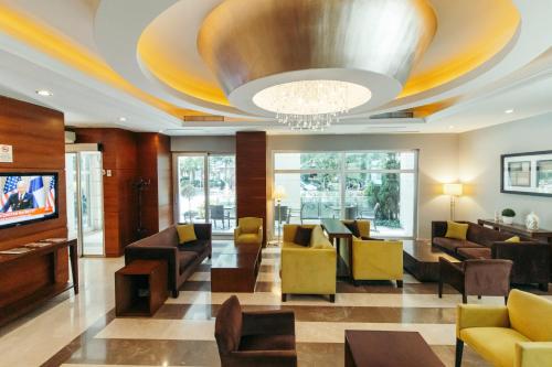 a lobby with couches and chairs and a television at CK Farabi Hotel in Ankara