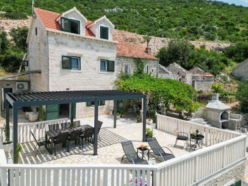 a balcony with a table and chairs and a house at Luxury Villa Navis in Orebić