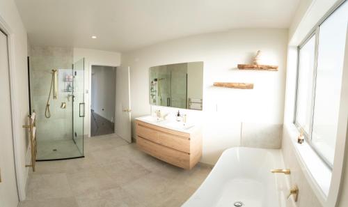 a bathroom with a tub and a sink and a shower at Boundary Retreat Twizel in Twizel