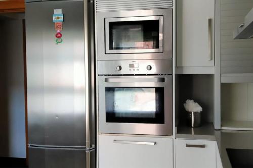 uma cozinha com 2 fornos e um micro-ondas em Apartamento Lekeitio, Garaje y WIFI em Lekeitio