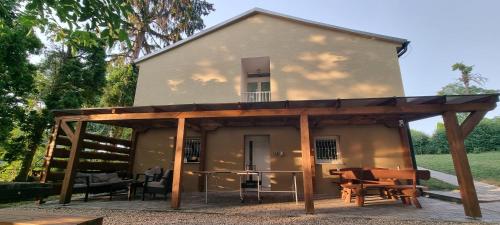 a house with a covered patio in front of it at Chata nad kúpaliskom Santovka in Santovka