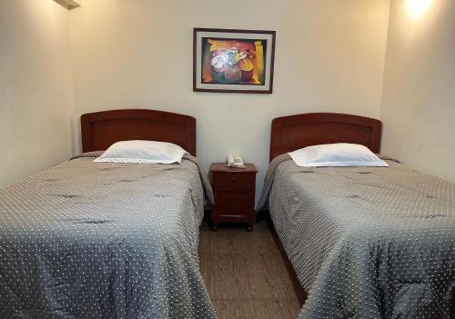 dos camas sentadas una al lado de la otra en una habitación en Hotel Palmas Reales, en Trujillo