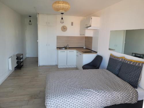 une petite chambre avec un lit et une cuisine dans l'établissement logement vue sur mer, à Canet