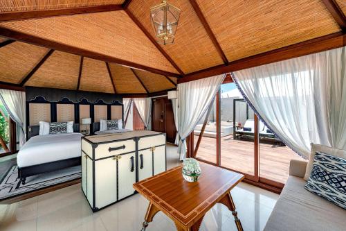 um quarto com uma cama e um tecto de madeira em The Ritz-Carlton Ras Al Khaimah, Al Hamra Beach em Ras al-Khaimah