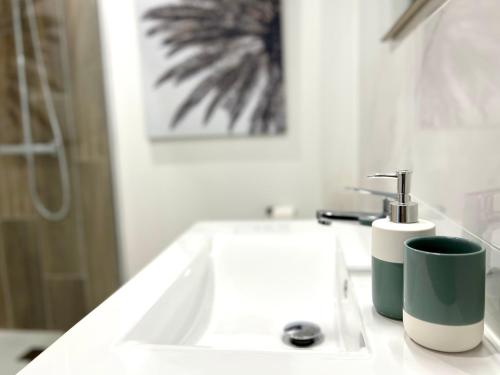a bathroom with a sink with a toothbrush and a cup at Appartement ~ L'Amour à la Plage ~ à 15min de Lyon in Miribel