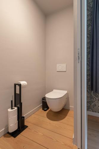 a bathroom with a toilet in the corner of a room at B&B T'Rest - Park ter Rijst in Heikruis