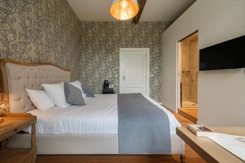 a bedroom with a large bed and a television at B&B T'Rest - Park ter Rijst in Heikruis