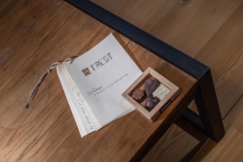 a book and a tiny box on a table at B&B T'Rest - Park ter Rijst in Heikruis