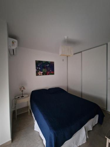 een slaapkamer met een blauw bed in een witte kamer bij Altos del Pampa in Santa Rosa